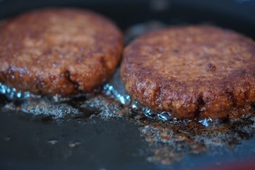Burger patties cooking in oil 